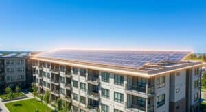 Modern apartment building with extensive solar panel installation on the roof, showcasing renewable energy solutions for sustainable living.